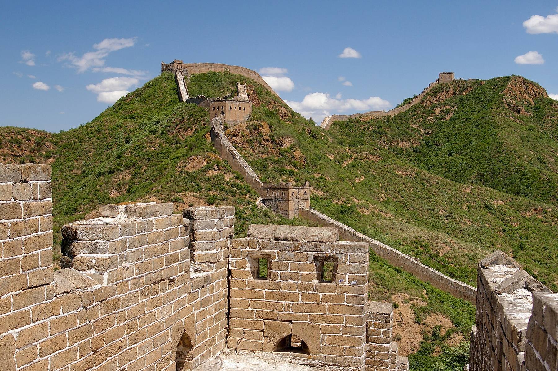 The Great Wall at Jinshanling winding over green hills under a blue sky